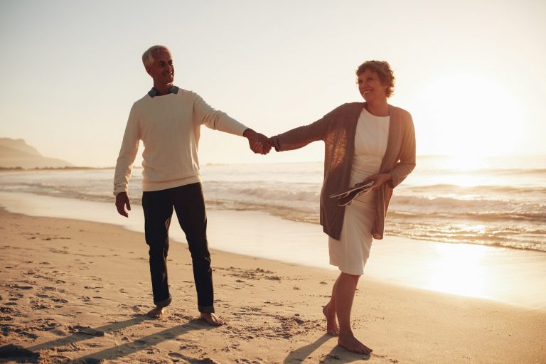 A middle aged couple hold hands as they walk along the beach. This symbolizes the benefits of couples therapy and marriage counseling in Pasadena, CA. Contact a marriage counselor to learn more about marriage counseling in Pasadena, CA for support! 91101 | 95814 | 95688 | 95765