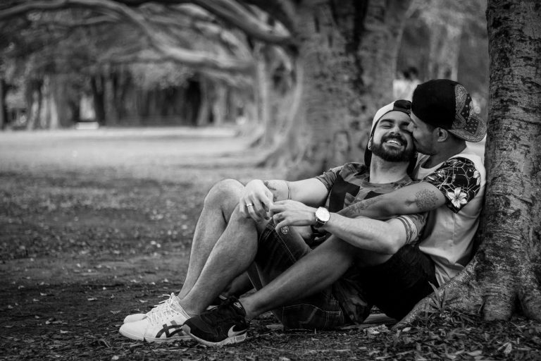A gay couple sit together against a tree as they laugh. This represents the benefits of couples therapy and affair recovery counseling in Pasadena, CA. Contact a marriage counselor in Pasadena, CA for support! Marriage counseling in Sacramento, CA can also support your relationship. 91101 | 95814 | 95688 | 95765