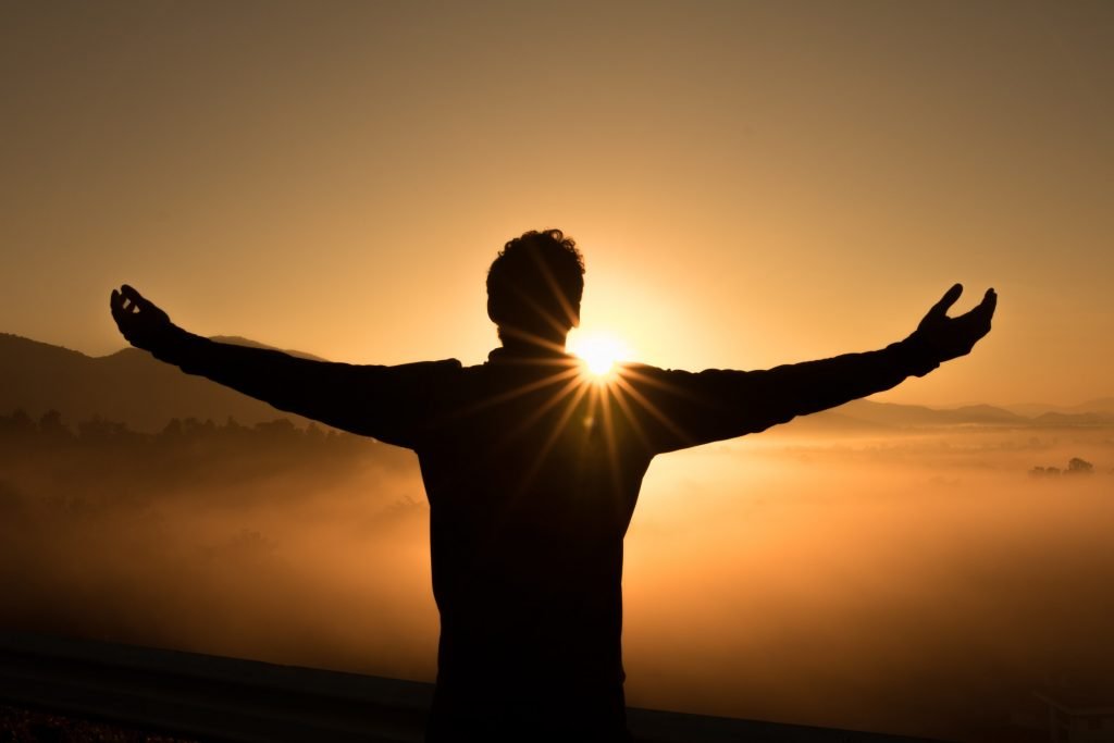 A silhouette extends their arms as they watch the sunrise. This could represent overcoming trauma with a trauma therapist in Sacramento, CA. Contact us today to learn more about somatic experiencing in Pasadena, CA, PTSD treatment in Pasadena, CA, and other services. 95624 | 95688 | 95765