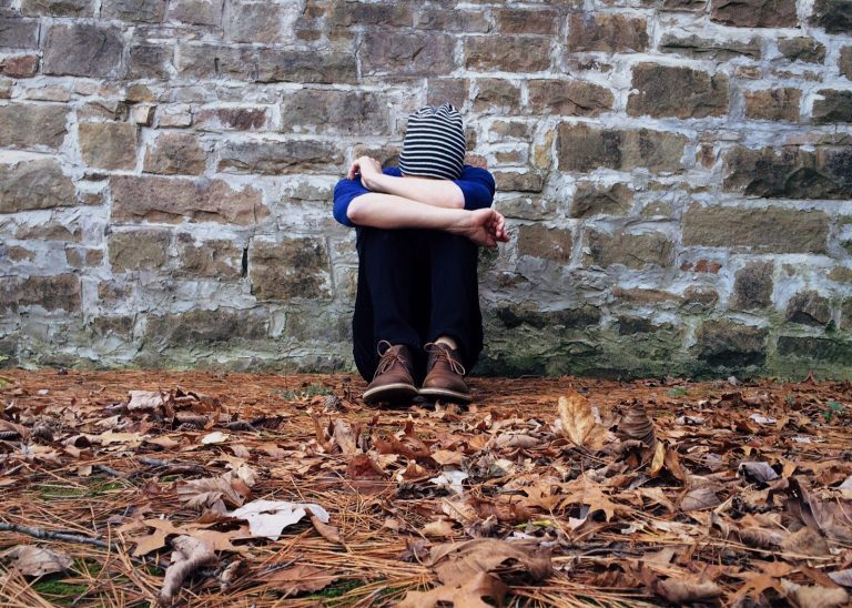 A person sits on fall leaves against a brick wall. Depression treatment in Sacramento, CA can provide support with overcoming depression symptoms. Contact a depression therapist in Pasadena, CA for support with online depression therapy in California and other services. 95814 | 95688 | 95765