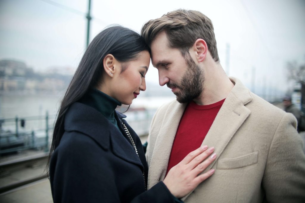A couple stands foreheads touching in an intimate moment of connection fostered by Couples Therapy in Pasadena, CA.