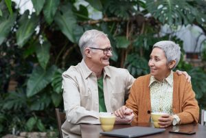 An older couple sits together have coffee representing a couple who has built a strong foundation with the help of Couples Therapy in Pasadena, CA.