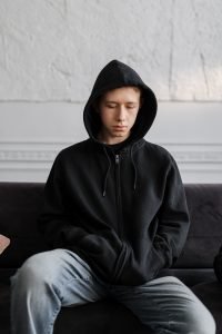 A teenager looking depressed sitting on a couch. Teen therapy pasadena is a service we offer at California Integrative Therapy in Pasadena. 91101